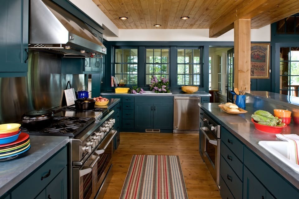 Colorful kitchen remodel with turquoise cabinets and stainless steel countertops.